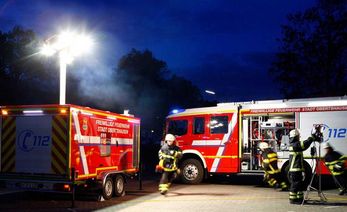 Feuerwehrwägen und -männer im Dunkeln Feuerwehrwägen und -männer im Dunkeln