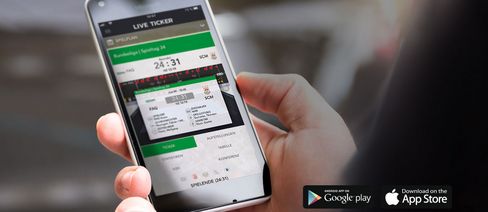 Hand hält ein Smartphone, auf dem ein Live Ticker der SCM App zu sehen ist